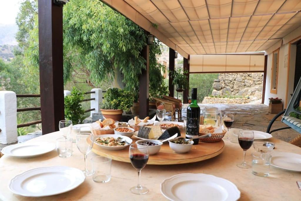 un tavolo con bicchieri di vino e cibo sopra di El Marqués, magnífica casa rural con piscina a Almería