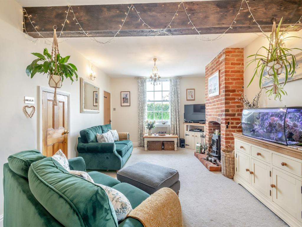 uma sala de estar com um sofá e um aquário em Bells Cottage em Wrentham