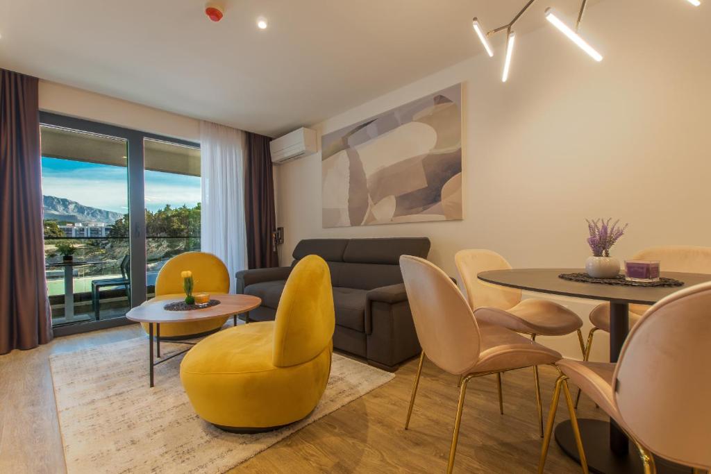 a living room with a couch and a table and chairs at Lux Ella Apartment in Makarska