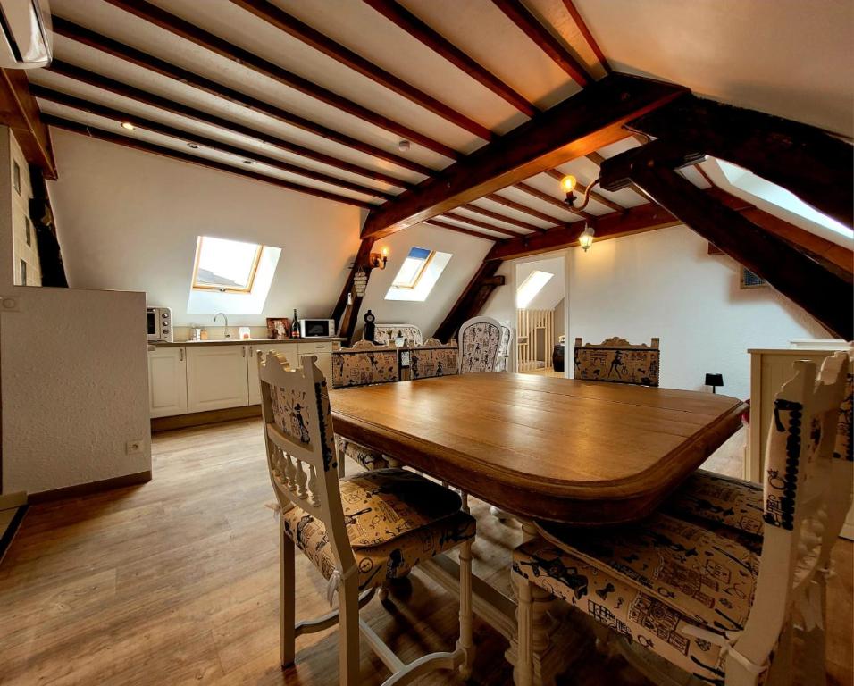 een eetkamer met een houten tafel en stoelen bij Au 1894 Loft in Avize