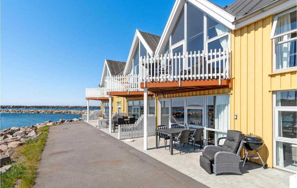 HasleにあるBeach Front Home In Hasleの黄色の家(デッキ、椅子、水付)