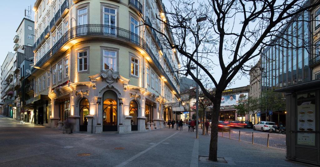 a building with a clock on it on a city street at Pestana Porto - A Brasileira, City Center & Heritage Building in Porto