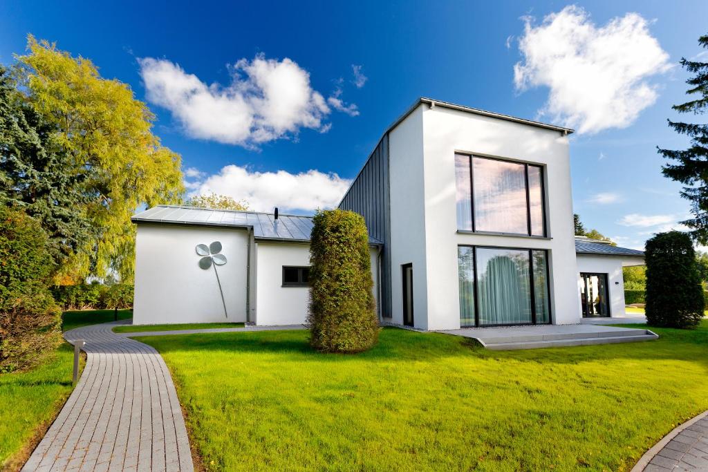 una casa blanca en un césped verde en Kleeblatthaus Putbus Rügen en Putbus