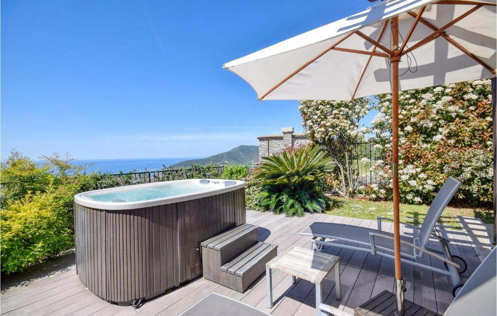 a patio with a hot tub and an umbrella at 3 Bedroom Beautiful Home In Moneglia in Moneglia