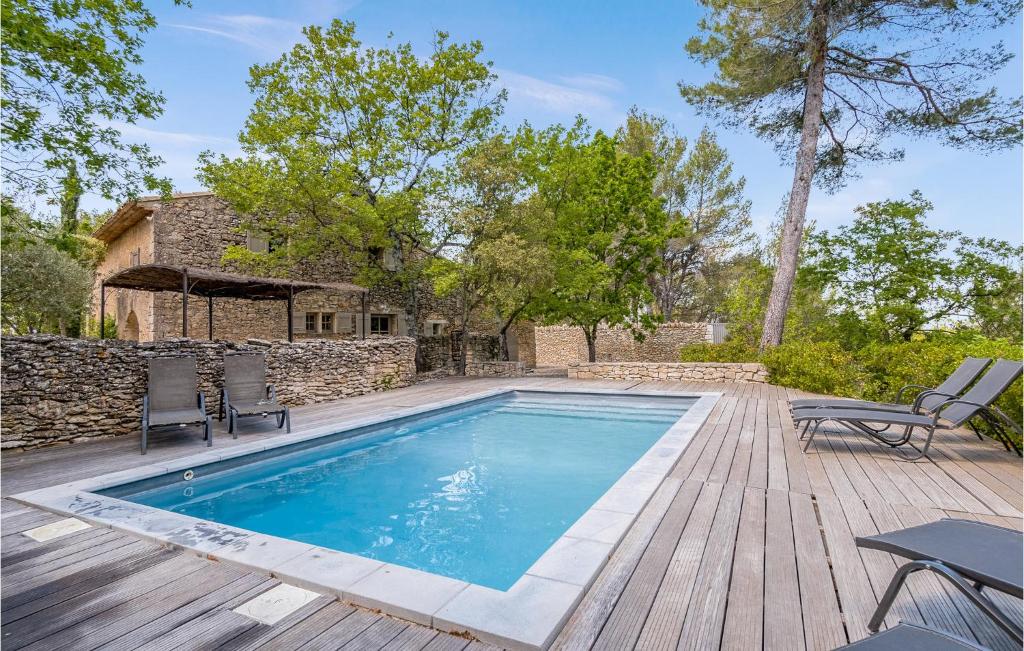a swimming pool on a wooden deck next to a house at Lovely Home In Lacoste With Kitchen in Lacoste
