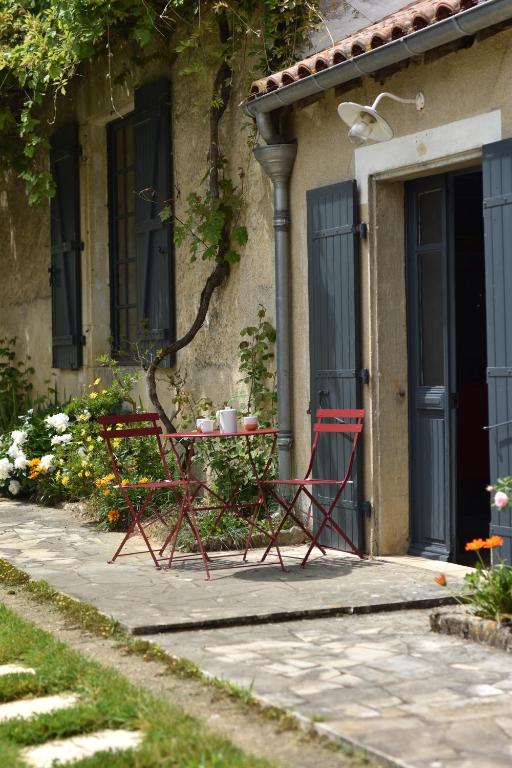 une table et des chaises devant une maison dans l'établissement Un jardin et trois maisons, à Brux