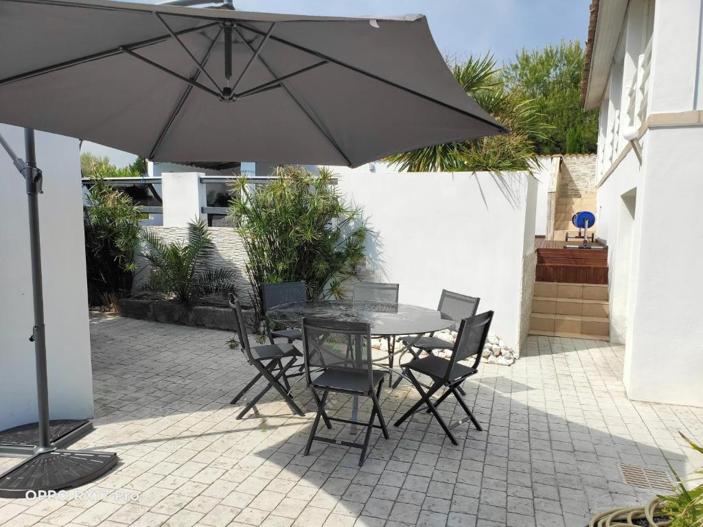 a table and chairs with an umbrella on a patio at Lavocette maison appartement in Le Grau-dʼAgde