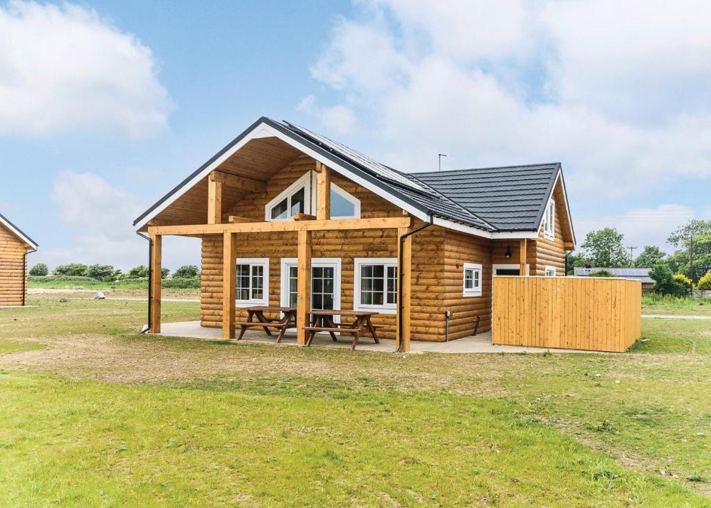 a log cabin with a picnic table in a field at Hornsea Lakeside Lodges in Hornsea