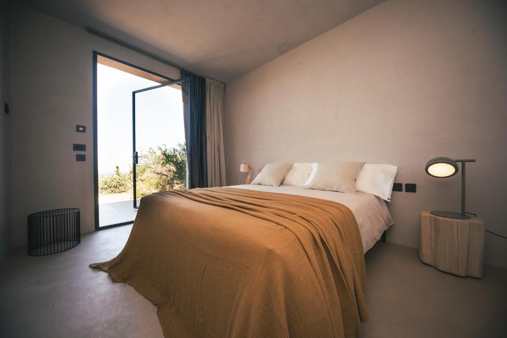 a bedroom with a large bed with a large window at Rakalia Pure Living Sicilian Retreat in Marsala