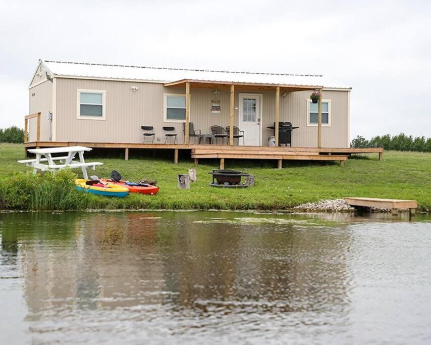 dom z łodzią przed jeziorem w obiekcie Luxury Lakefront Wolf Lodge with Fishing and Boating w mieście Commerce