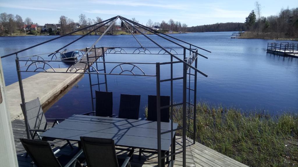 a table and chairs on a dock next to the water at Bommarvikens Bed & Breakfast in Olofström