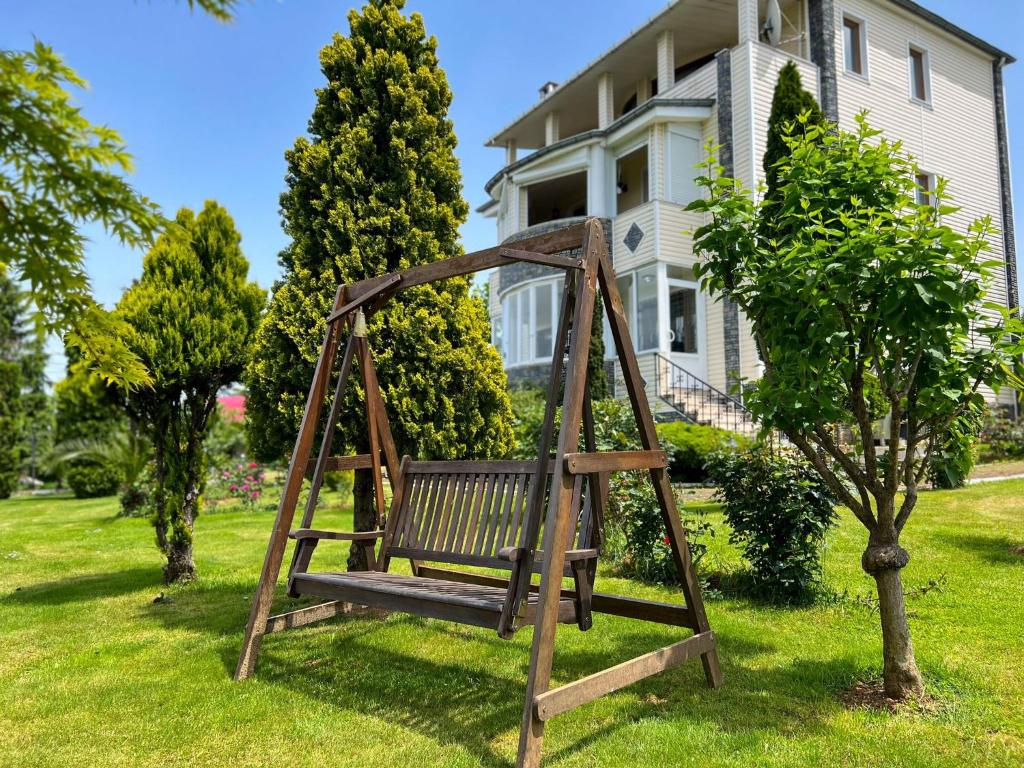 a wooden swing in a yard in front of a house at Heaven Garden Villa in Trabzon