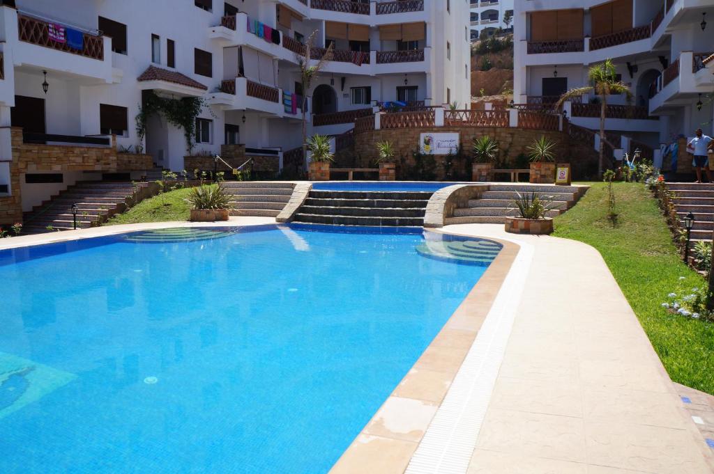 a swimming pool in front of a building at Apartment Residence Al Kassaba, Beach, Pool, Fast Wifi in Oued Laou