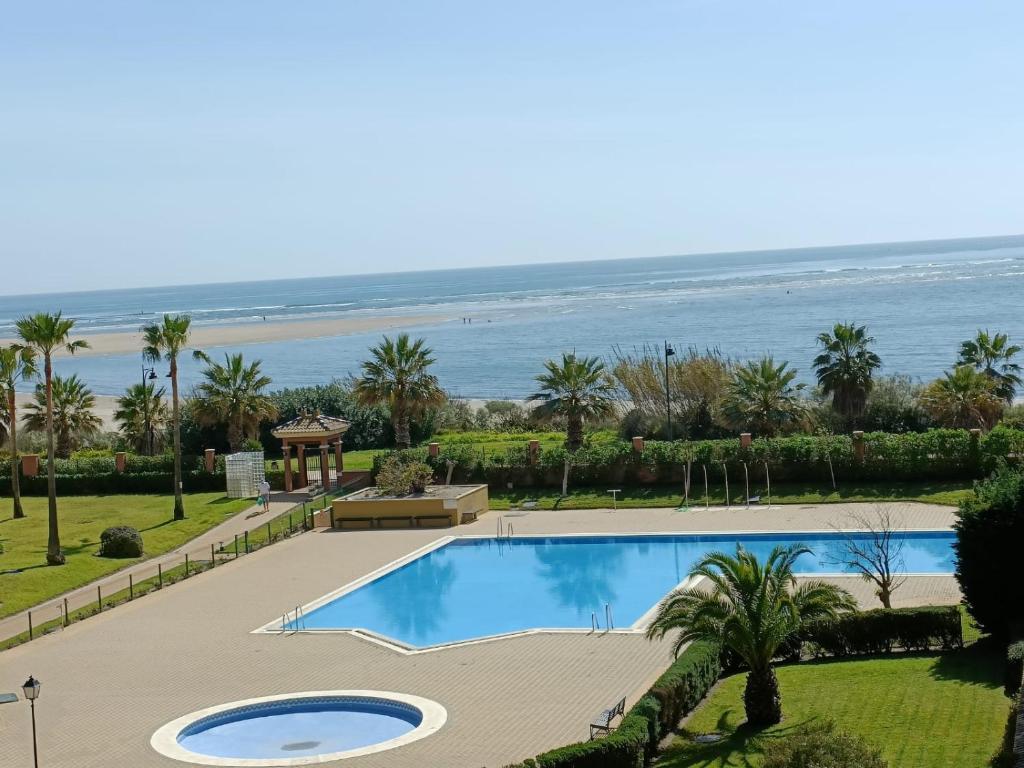 widok na basen i plażę w obiekcie Urbanización Los Cisnes by SIT ISLA CANELA w mieście Isla Canela