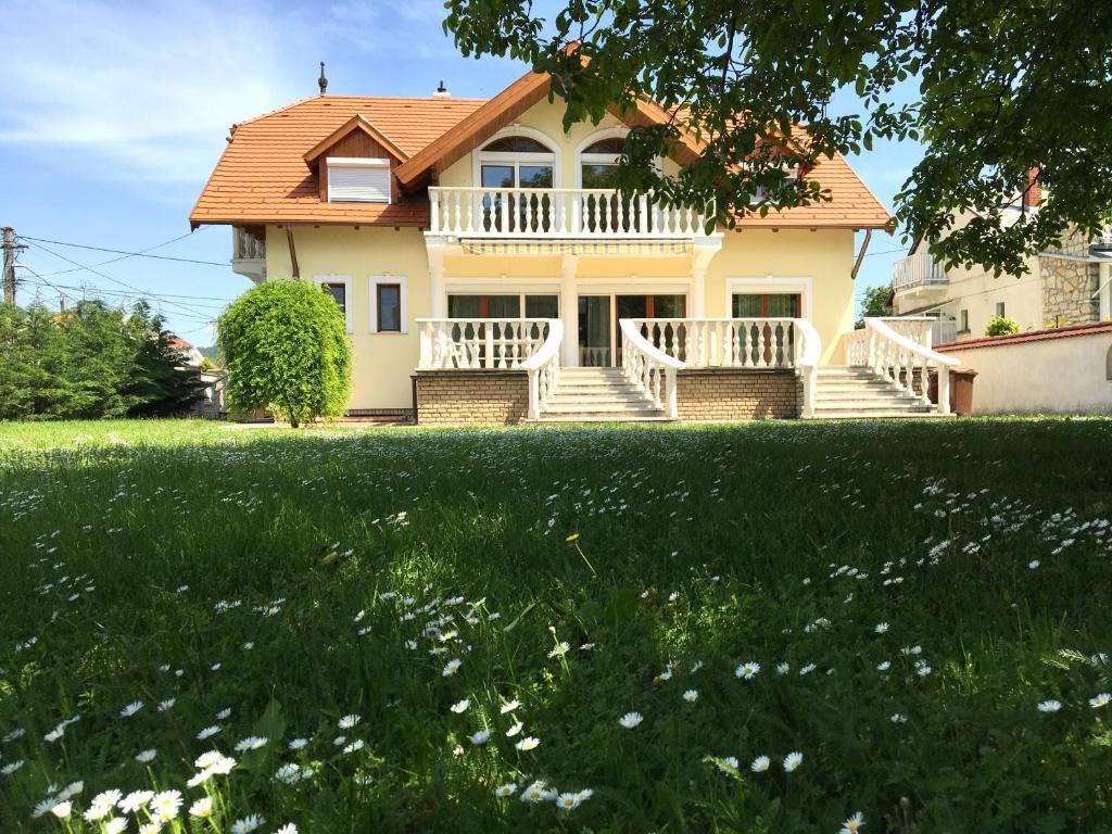 una casa con un gran patio con flores en Csók Apartmanház, en Balatonfüred