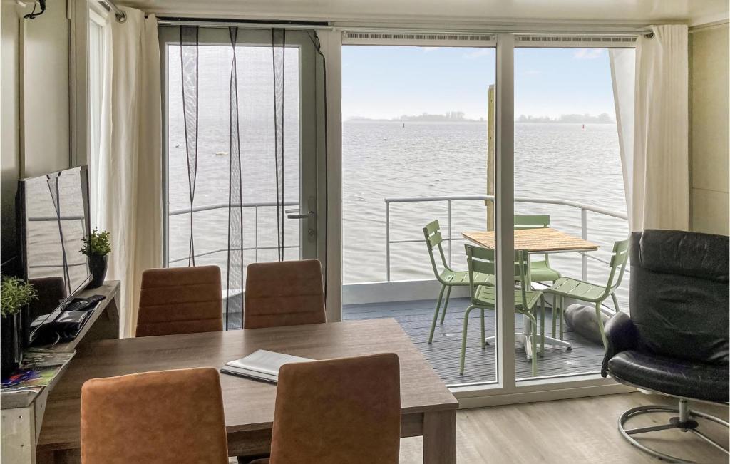 een eetkamer met een tafel en uitzicht op het water bij Nice Ship In Biddinghuizen With Kitchen in Biddinghuizen