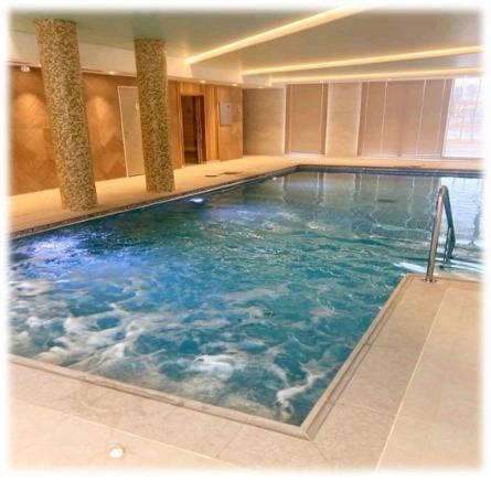 una grande piscina con acqua blu in un edificio di Domitys Les Cépages a Gaillac