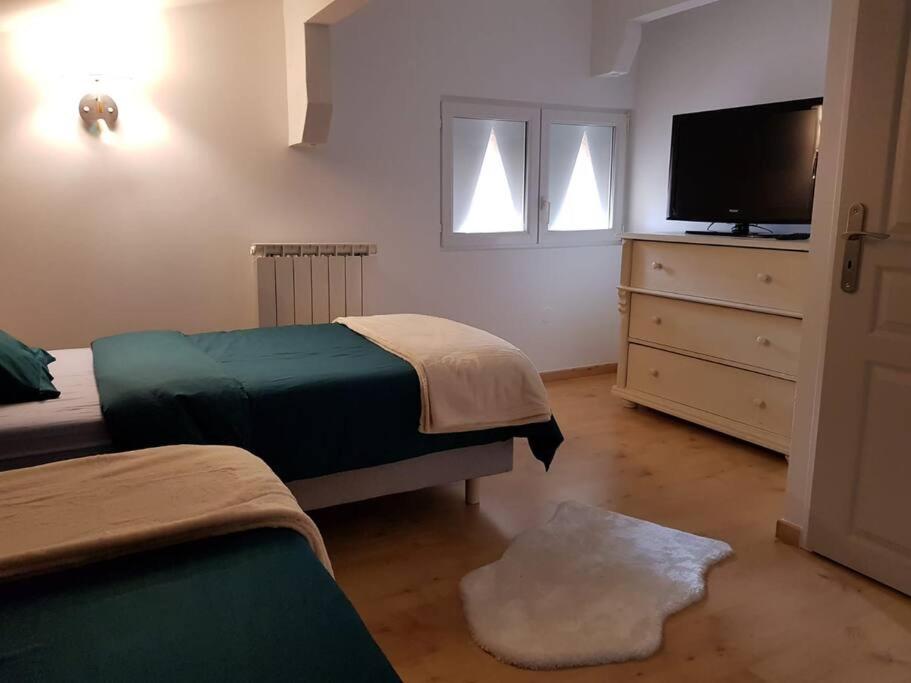 - une chambre avec 2 lits et une télévision à écran plat dans l'établissement Appartement étoilé duplex tout confort, à Gérardmer