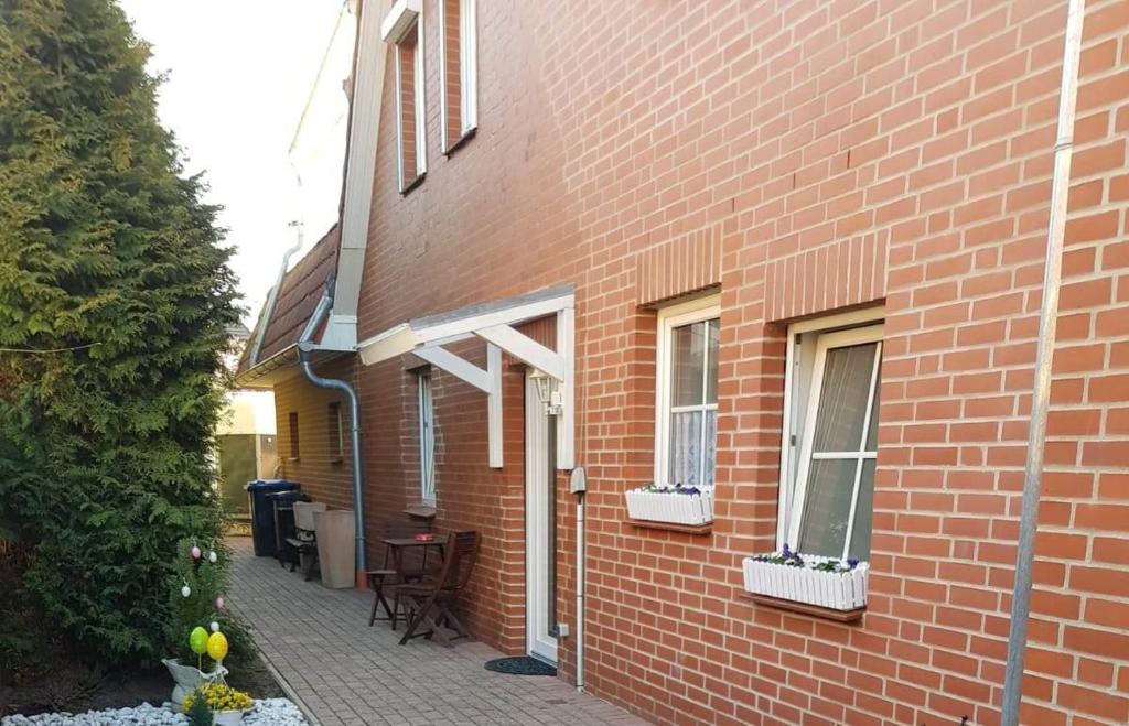 a red brick building with two windows and a patio at Ferienwohnung Conny in Winsen