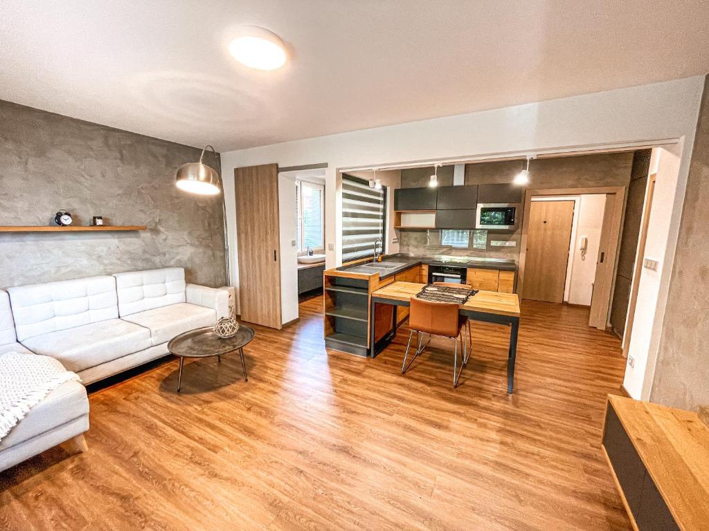 a living room with a white couch and a kitchen at Vantisch Apartment in Vlašim