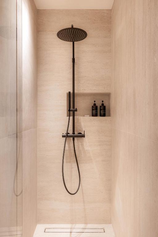 a shower with a shower head in a bathroom at Doryssa Theorem Hotel in Pythagoreio