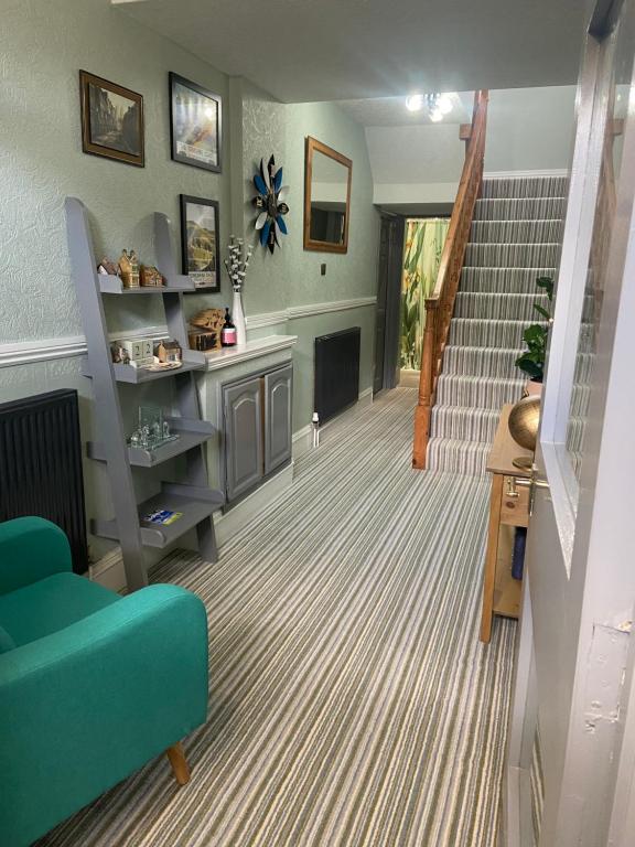 a living room with a staircase and a blue couch at The Old Surgery Room Only in Scarborough