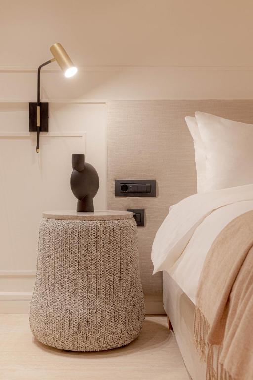 a bedroom with a bed and a table with a lamp at Doryssa Theorem Hotel in Pythagoreio