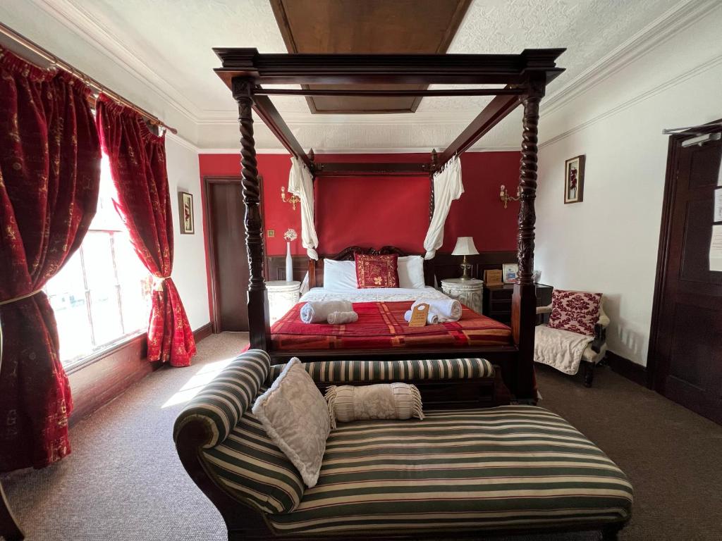 ダービーにあるGeorgian House Hotelのベッドルーム(天蓋付きベッド1台、ソファ付)
