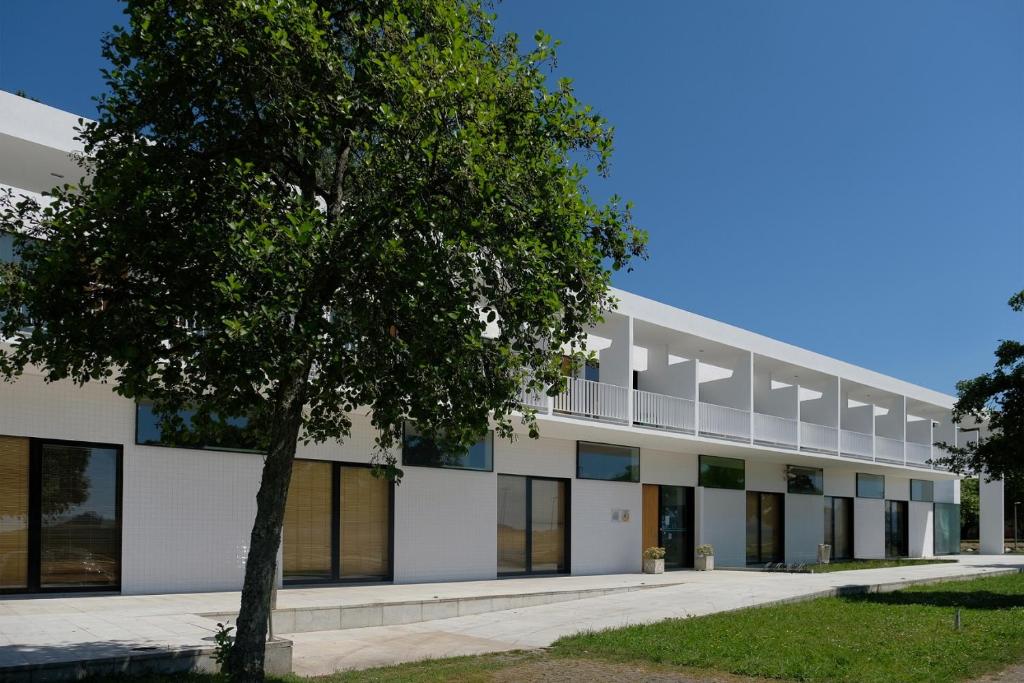 ein Bürogebäude mit einem Baum davor in der Unterkunft HI Viana do Castelo - Pousada de Juventude in Viana do Castelo