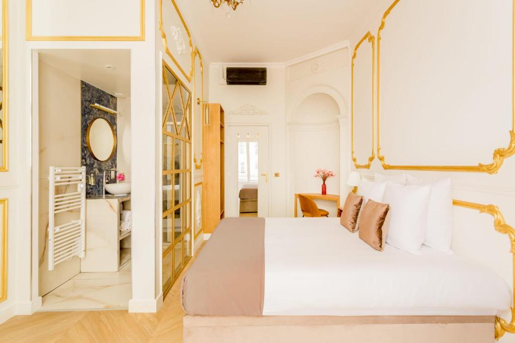 Schlafzimmer mit einem weißen Bett und einem Spiegel in der Unterkunft Luxury 4 bedroom 4 bathroom Apartment - Louvre in Paris