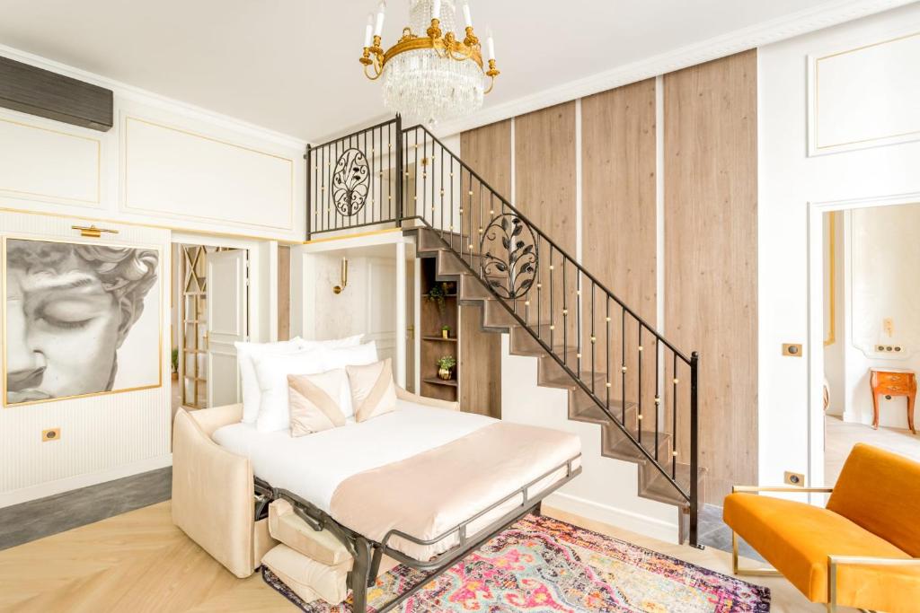 ein Schlafzimmer mit einem Bett und einer Treppe in der Unterkunft Luxury 4 bedroom 4 bathroom Apartment - Louvre in Paris