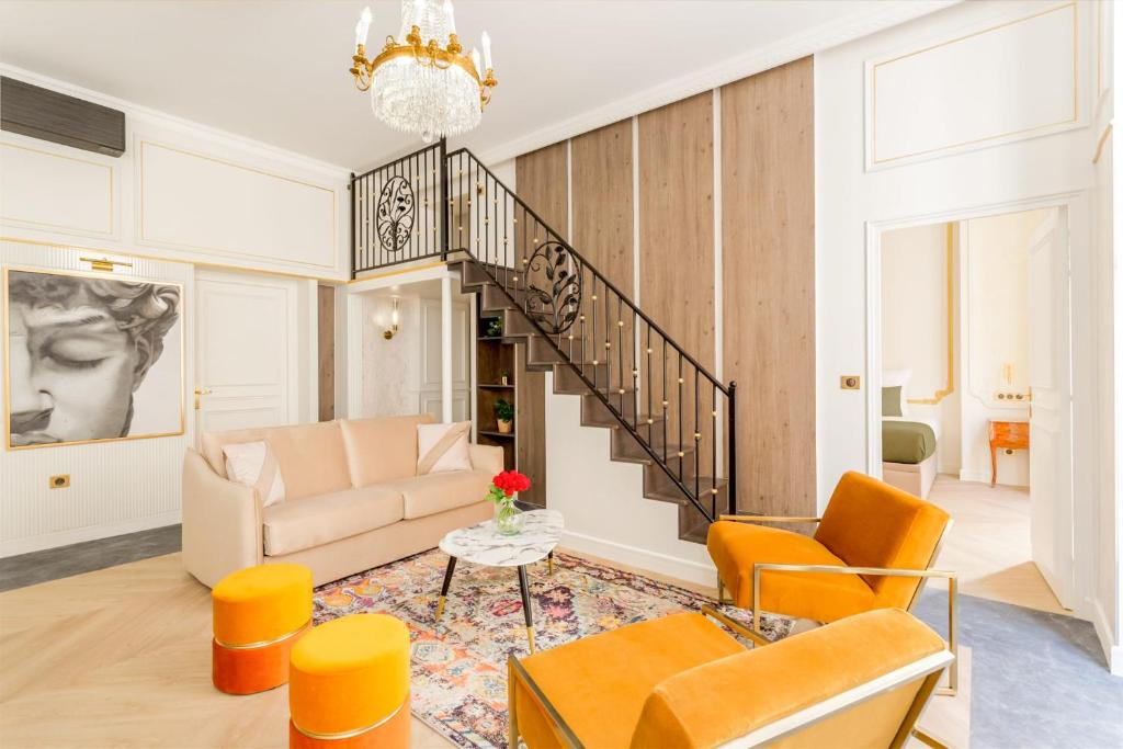 ein Wohnzimmer mit einer Treppe und orangefarbenen Stühlen in der Unterkunft Luxury 4 bedroom 4 bathroom Apartment - Louvre in Paris