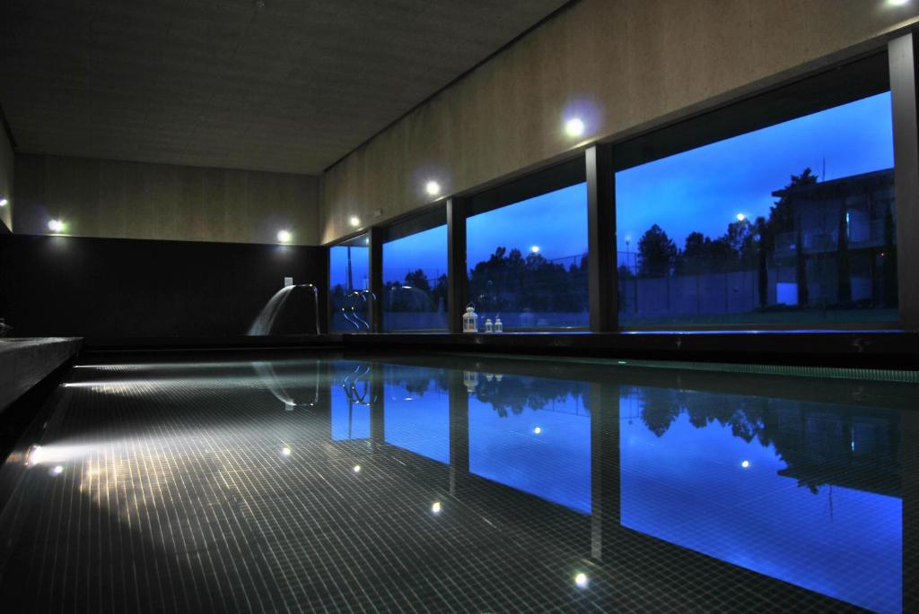 a swimming pool with a view of the night at Hotel Quinta da Cruz & SPA in Ataíde