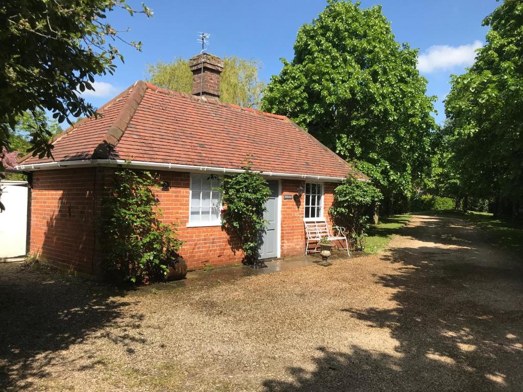 an old brick house with a chimney on a yard at The Gatehouse in Long Melford