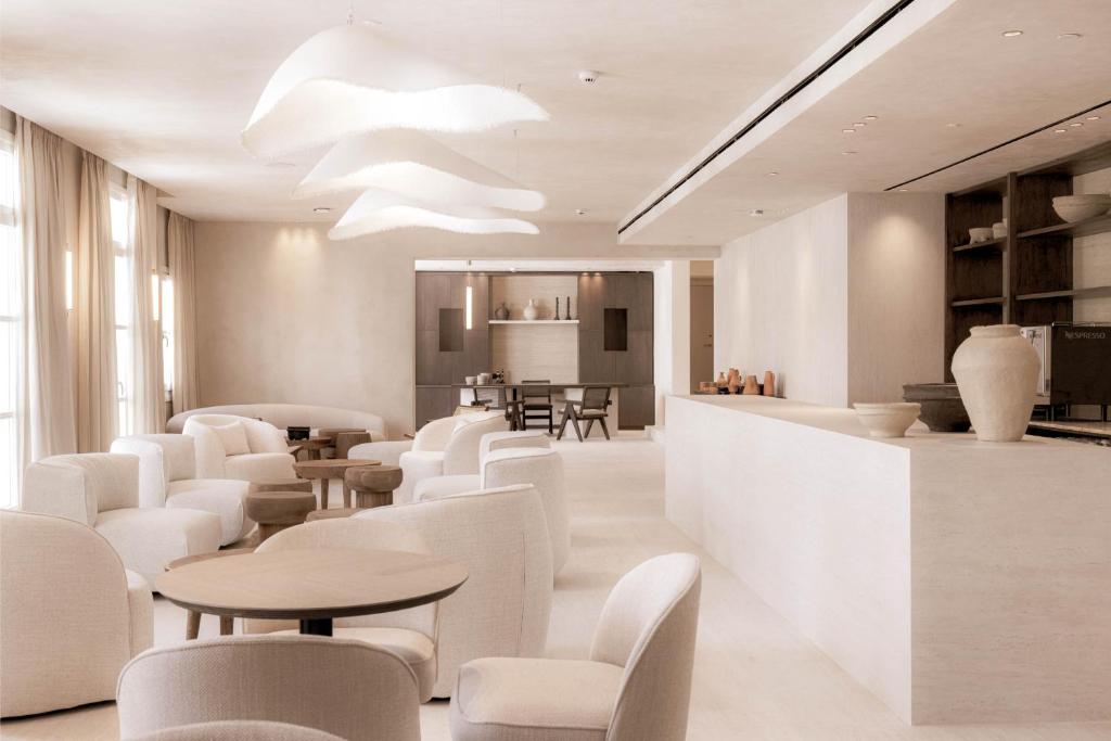 a waiting room with white chairs and tables at Doryssa Theorem Hotel in Pythagoreio