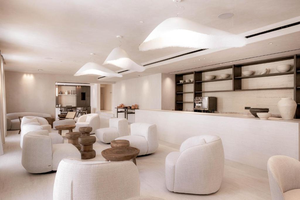ピタゴリオにあるDoryssa Theorem Hotelの白い椅子とカウンターが備わる待合室