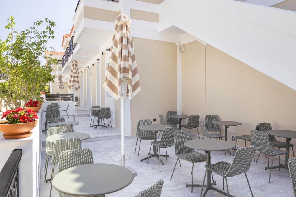 a row of tables and chairs in a restaurant at Doryssa Theorem Hotel in Pythagoreio