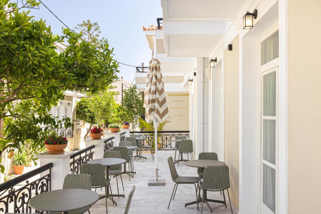 an outdoor patio with tables and chairs and plants at Doryssa Theorem Hotel in Pythagoreio