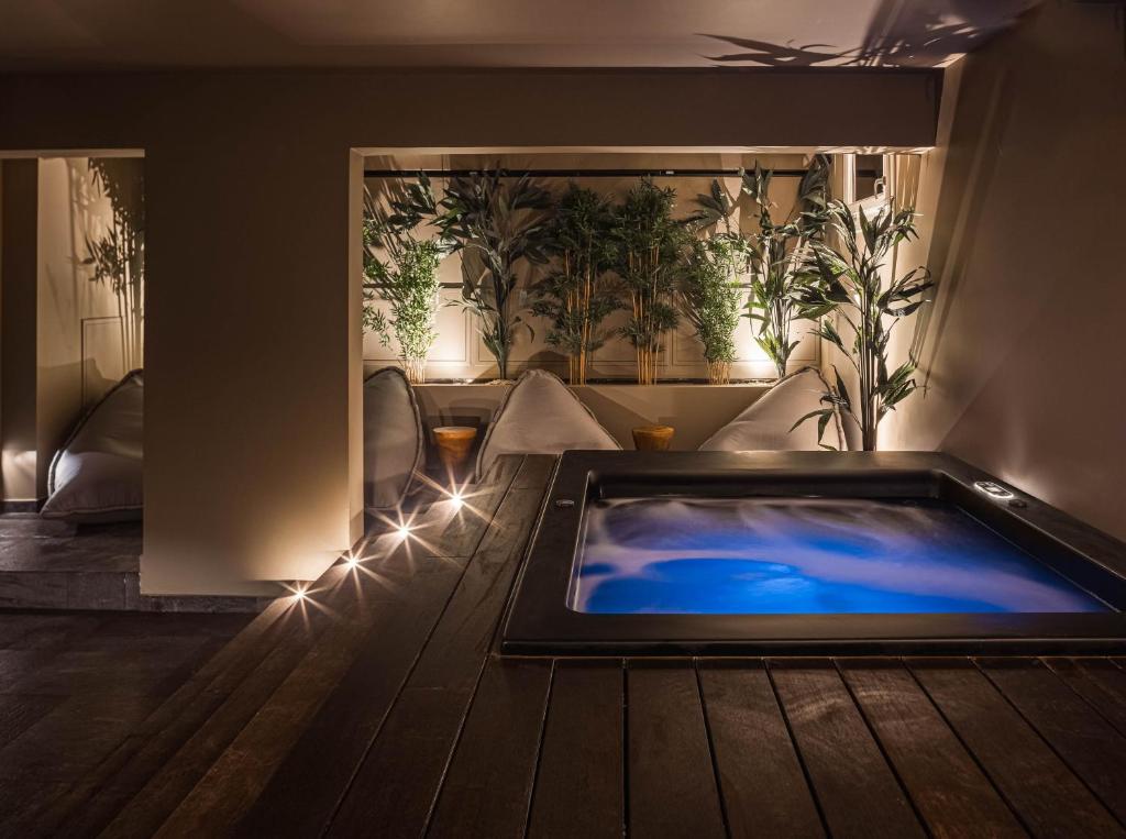 a hot tub in the middle of a room with plants at Doryssa Theorem Hotel in Pythagoreio