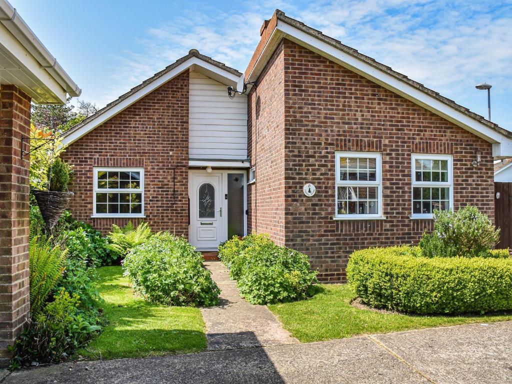 a brick house with a white door at Chimney Springs in Ormesby Saint Michael