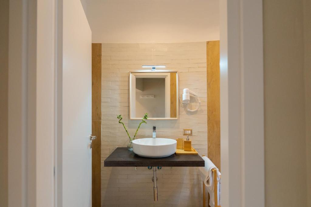 ein Bad mit einem Waschbecken und einem Spiegel in der Unterkunft La Casa di Leo - Rooms at the feet of Vesuvius in Boscotrecase