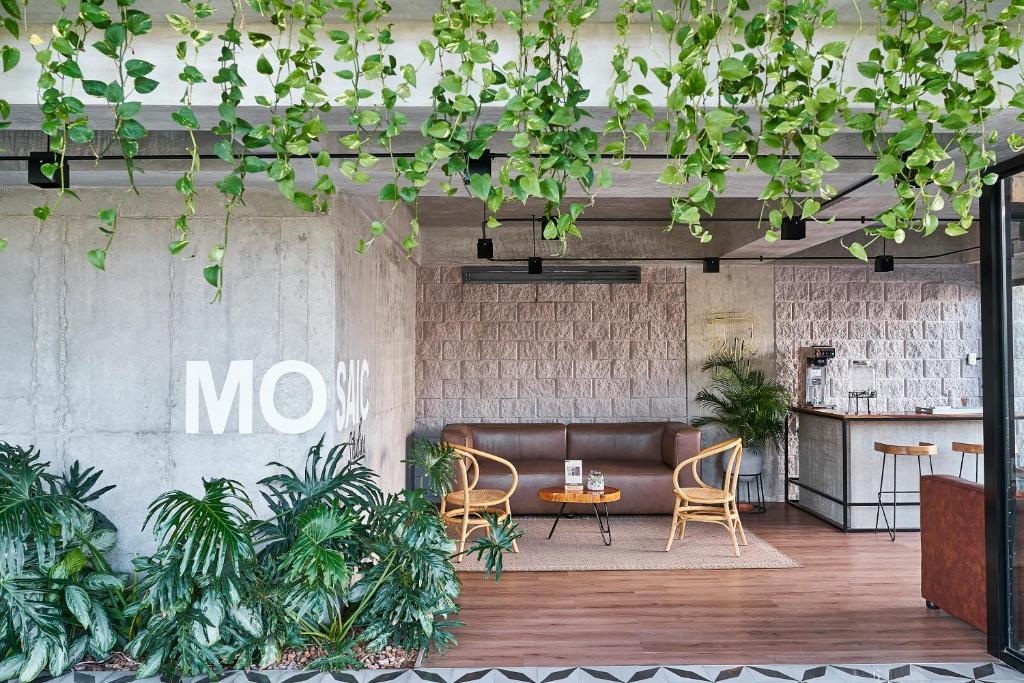 a lobby with a couch and chairs and plants at Mosaic Studios Buenavista in Barranquilla