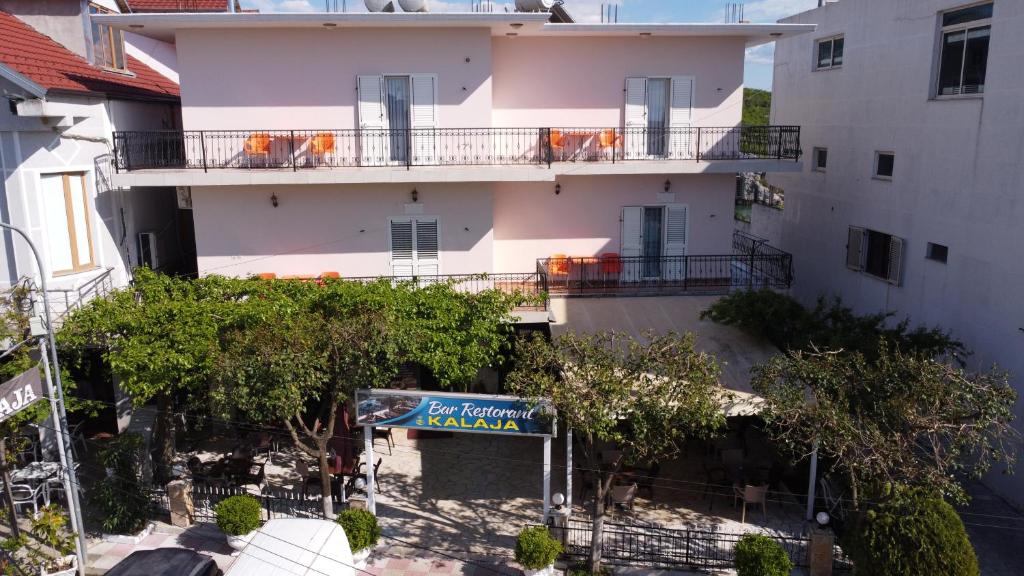 an apartment building with a sign in front of it at Hotel Kalaja in Shkodër