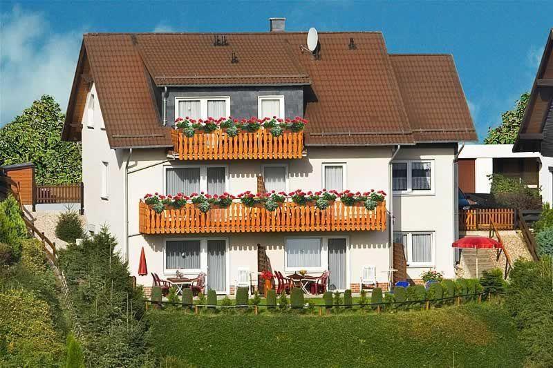 uma casa com uma varanda com flores em Urlaub-im-Haus-Nietmann-FW-2 em Altenau