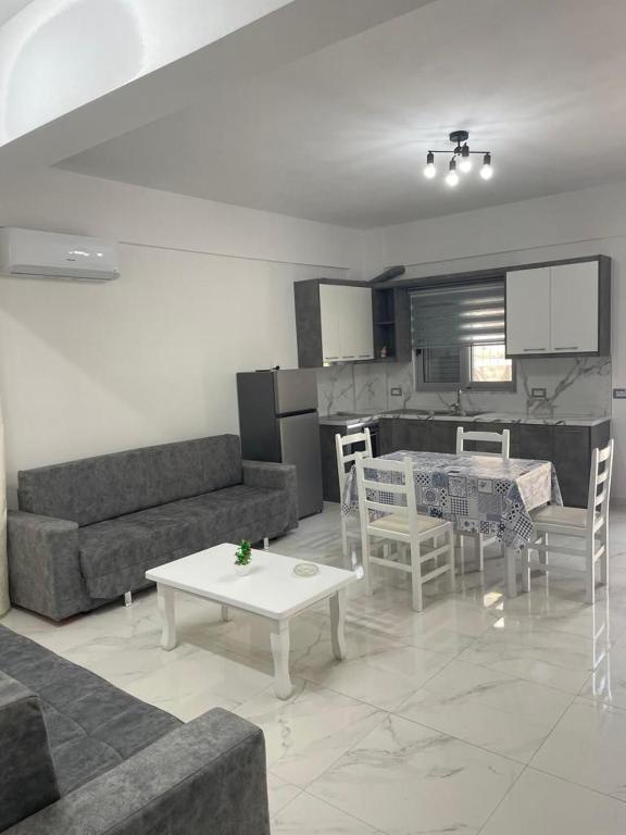 een woonkamer met een bank en een tafel bij Taku apartment in Sarandë