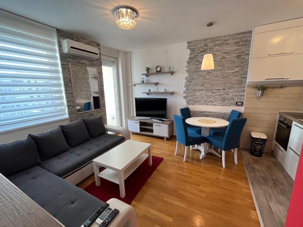 een woonkamer met een bank en een tafel bij Rona Apartments in Novi Sad