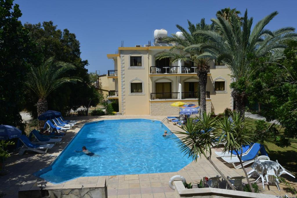una persona nadando en una piscina frente a una casa en Odysseas & Eleni Hotel Apartments en Polis Chrysochous