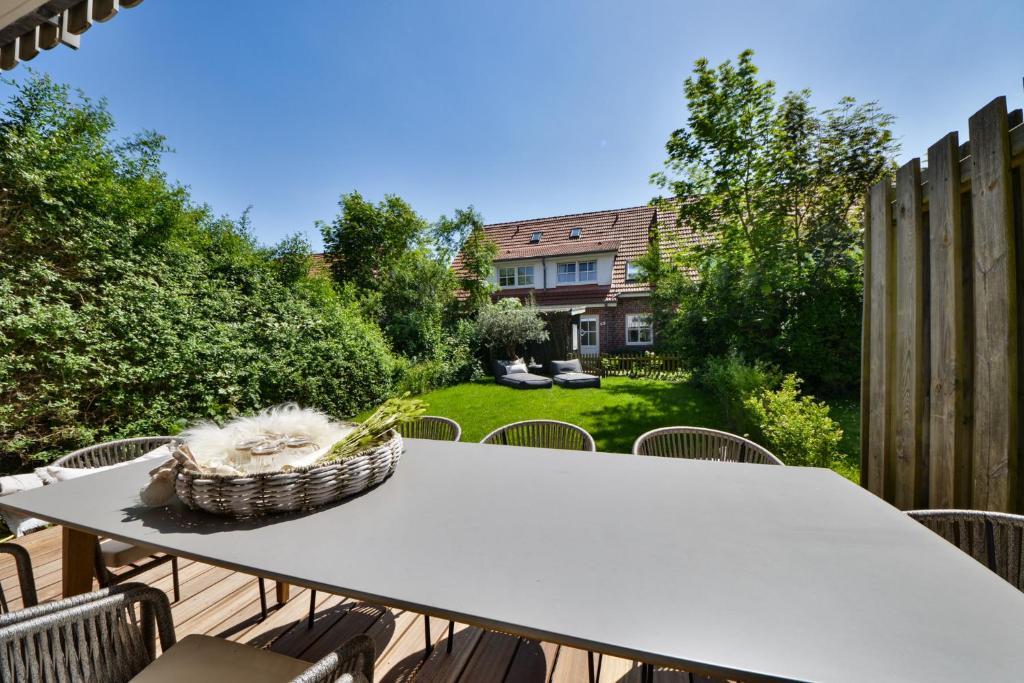 einen Tisch mit einem Korb auf der Terrasse in der Unterkunft Ferienhaus Olivenoog in Wangerooge