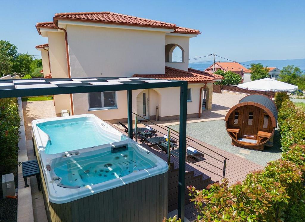 a hot tub on a balcony of a house at Holiday house SEA & SUN RESIDENCE in Rasopasno