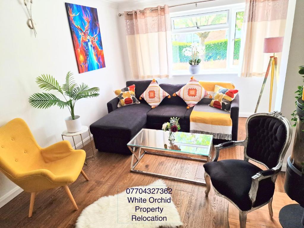 a living room with a blue couch and chairs at 4 Bed House Stevenage SG1 Free Parking & Wi-Fi Business & Families Serviced Accommodation by White Orchid Property Relocation in Stevenage